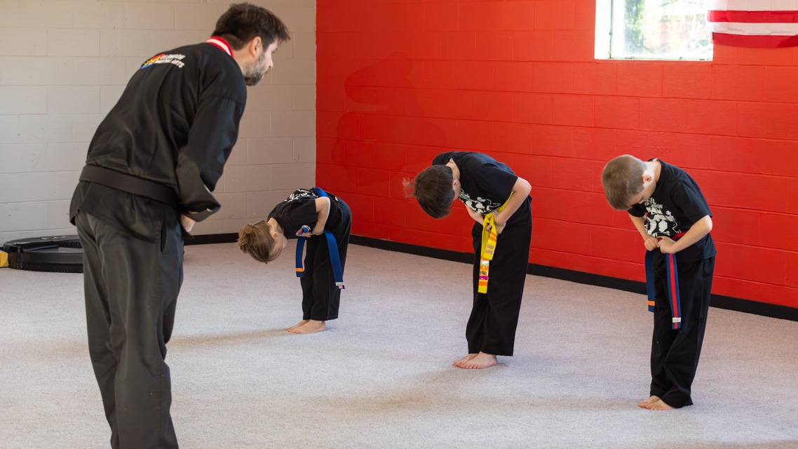 Young Kuk Sool students bow to instructor before training.